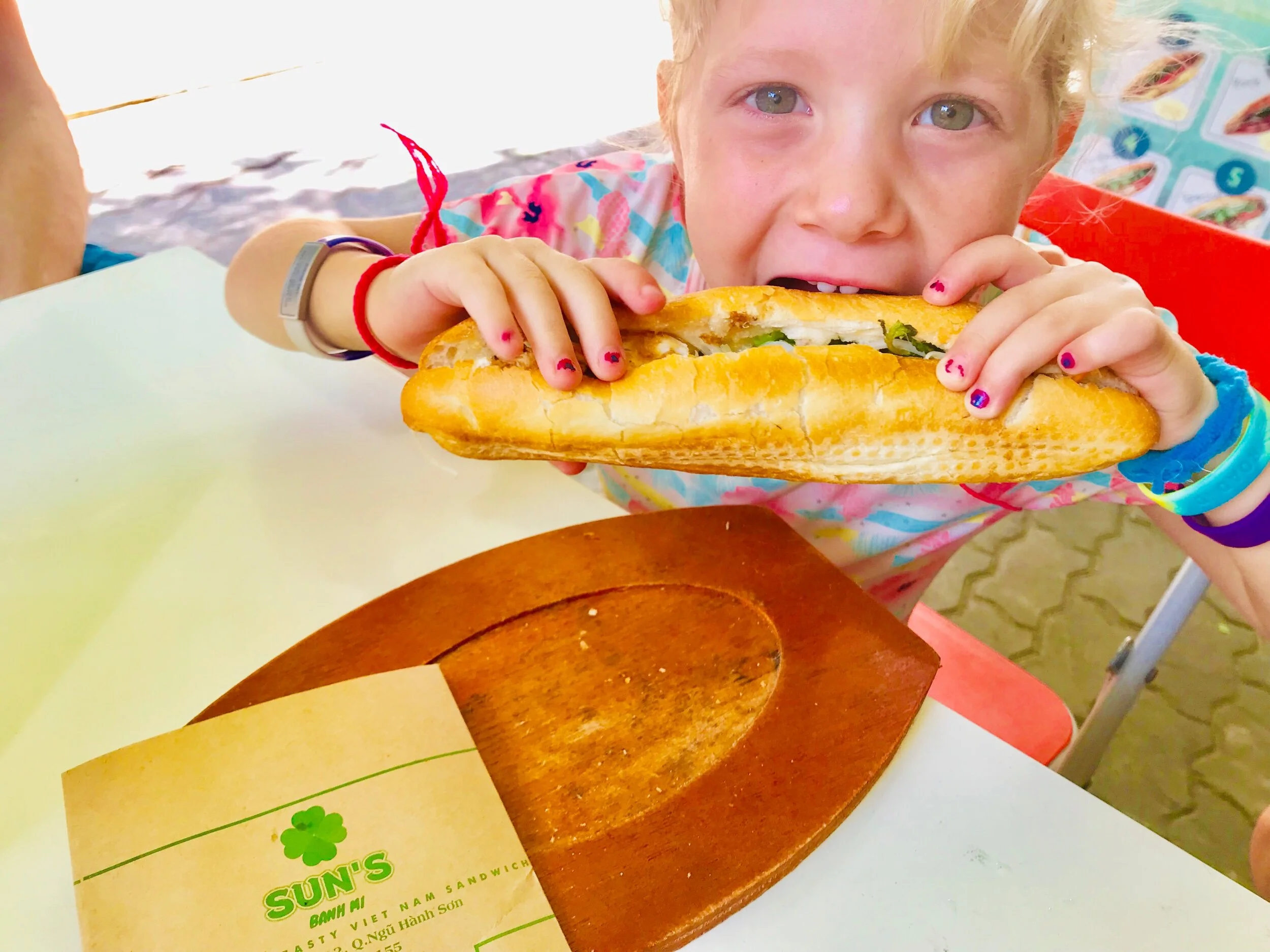 Madeline showing us the real way to eat a Banh Mi :)